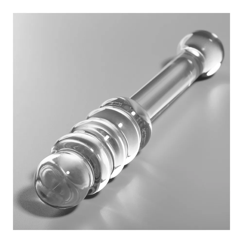 Emballage noir d'un gode en verre transparent avec deux extrémités différentes : perles en relief d'un côté, bille lisse de l'autre, tige cylindrique