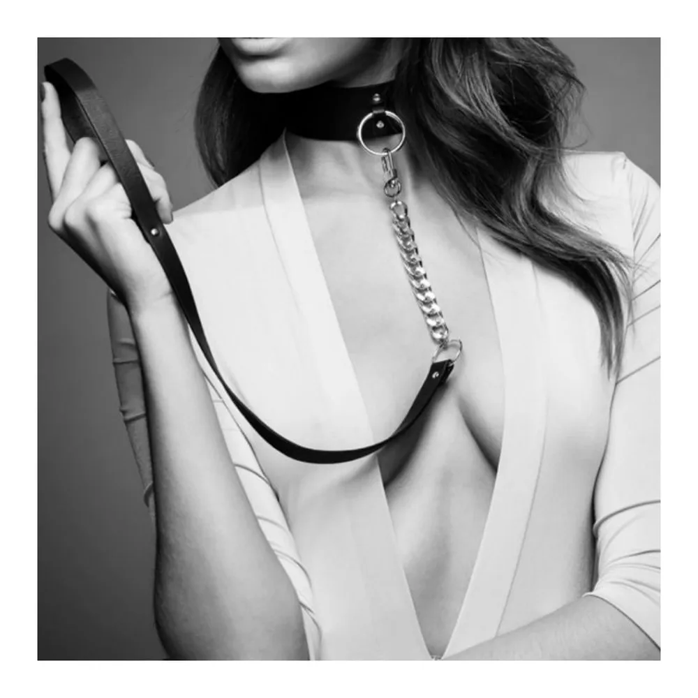 Collier large en cuir noir avec anneau de métal doré central, fermé par bouton-pression, et sangle ajustable sur le côté