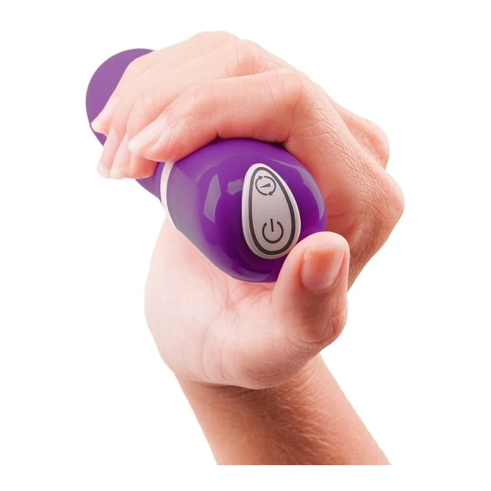 Boîte de vibromasseur Bdesired Deluxe Pearl violet avec femme souriante tenant le produit, deux embouts violets visibles à côté de l'emballage noir et blanc
