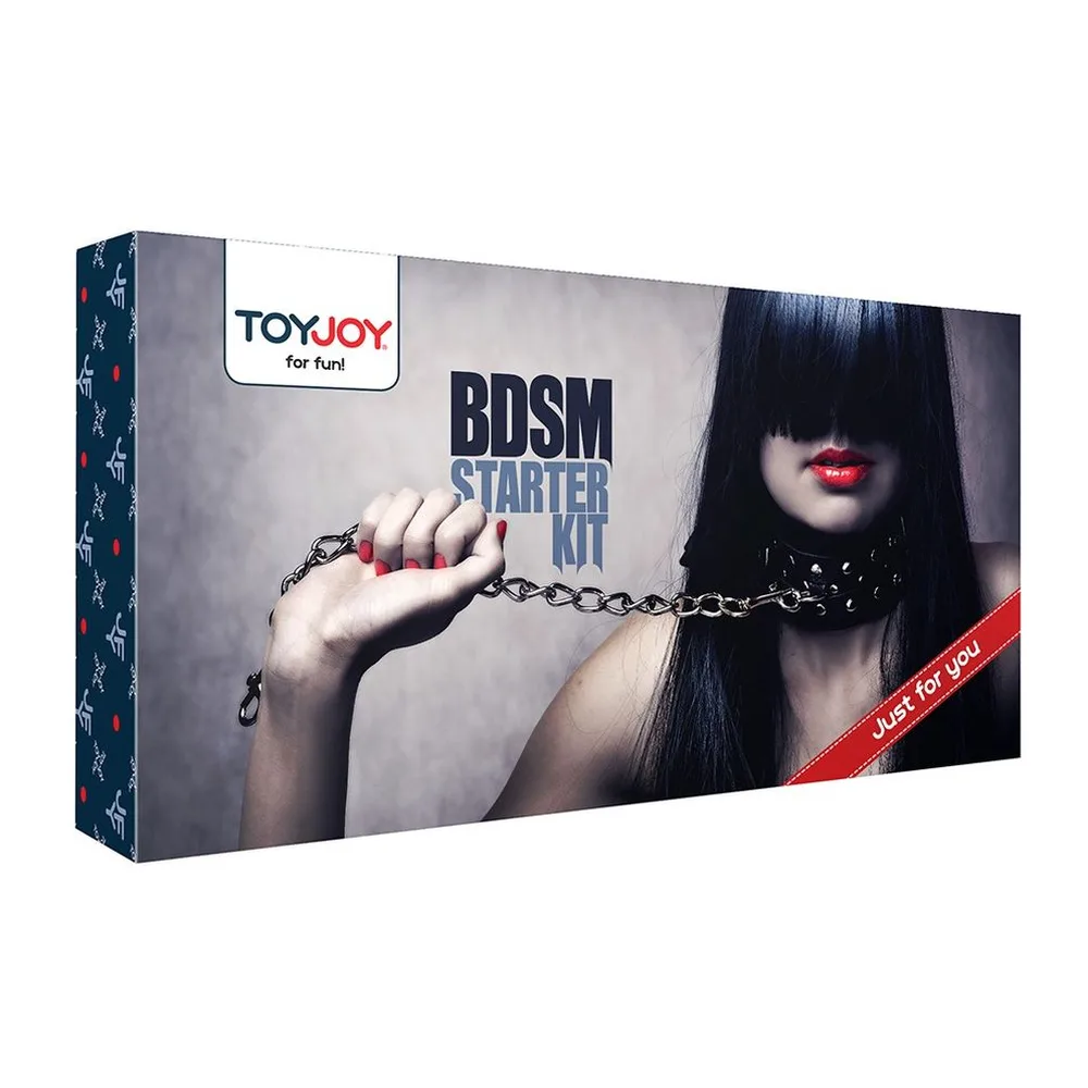 Kit BDSM noir composé de menottes, collier, fouet, masque, corde et pétales rouges, éléments disposés sur fond blanc