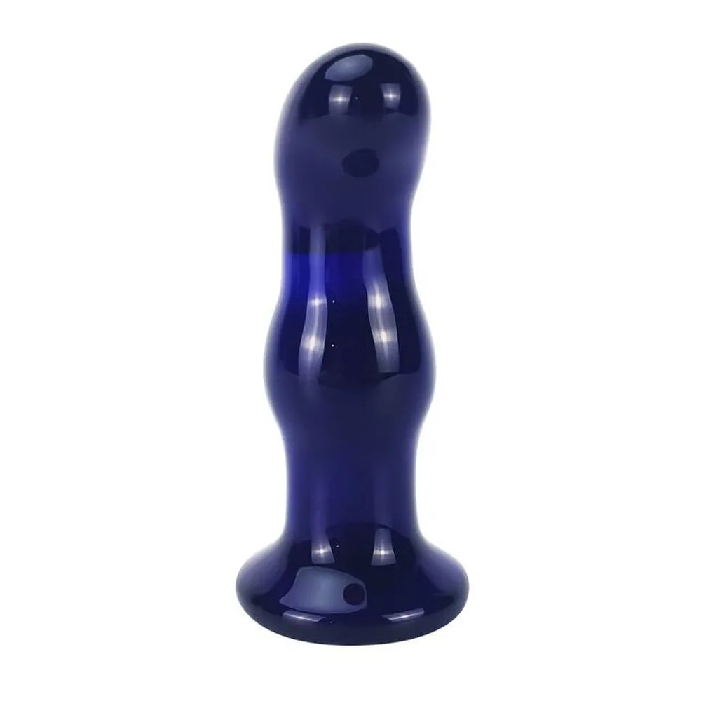 Vibromasseur en verre bleu foncé brillant, forme tubulaire avec deux renflements arrondis, base plate et large, orifice à l'extrémité supérieure, fond blanc