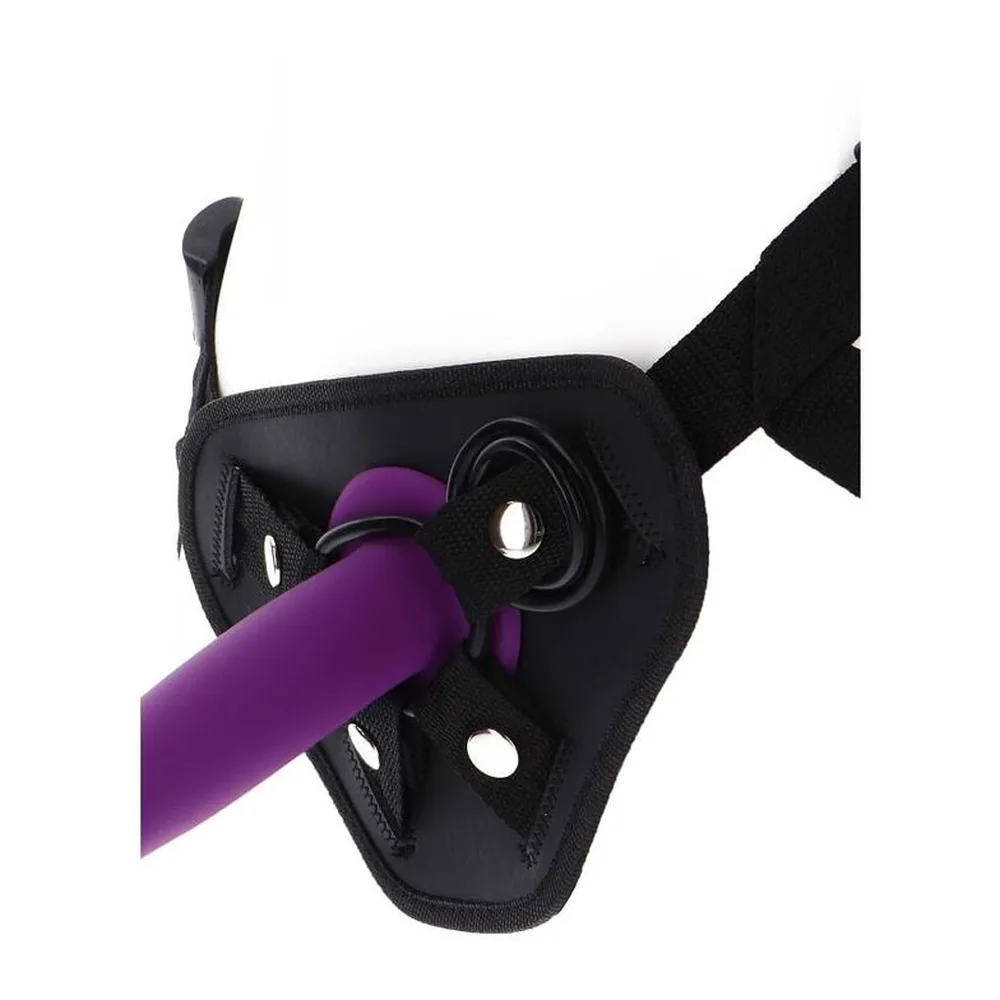 Harnais strap-on noir en tissu rembourré avec quatre rivets métalliques, deux anneaux de fixation en métal, lanières ajustables et branding TOYJOY, présenté à plat sur fond blanc