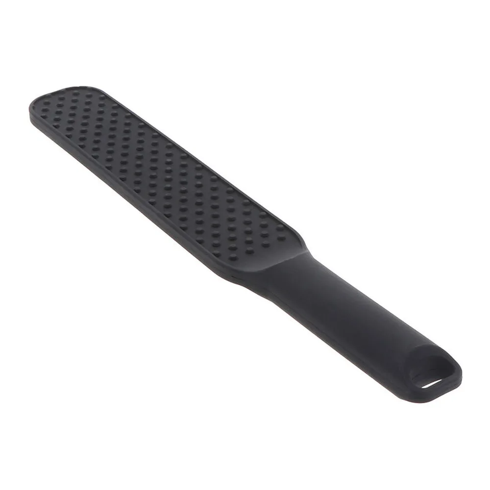 Paddle en silicone noir avec une face lisse et l'autre couverte de picots réguliers, manche épais et grip ergonomique sur fond blanc