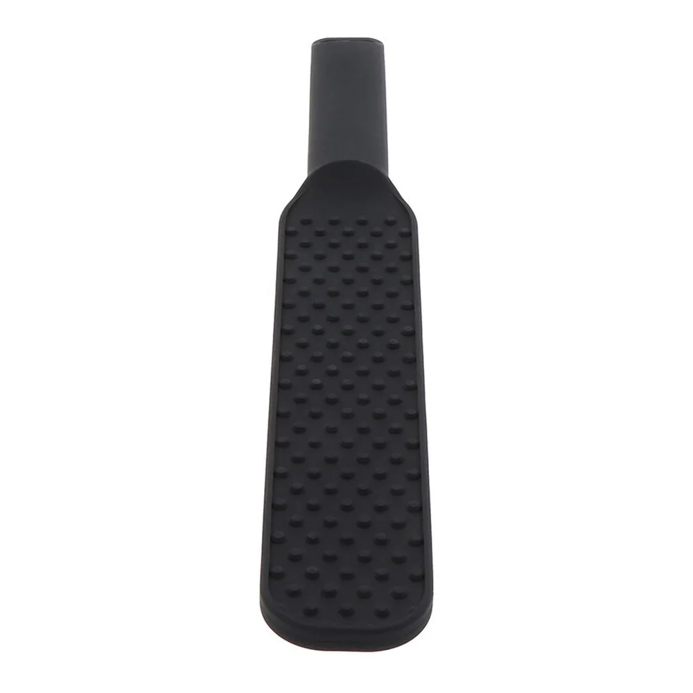 Paddle en silicone noir avec une face lisse et l'autre couverte de picots réguliers, manche épais et grip ergonomique sur fond blanc