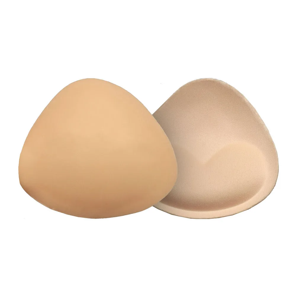 Deux coussinets push-up en silicone beige clair, en forme de goutte, présentés dans un soutien-gorge rose poudré ouvert, sur fond blanc