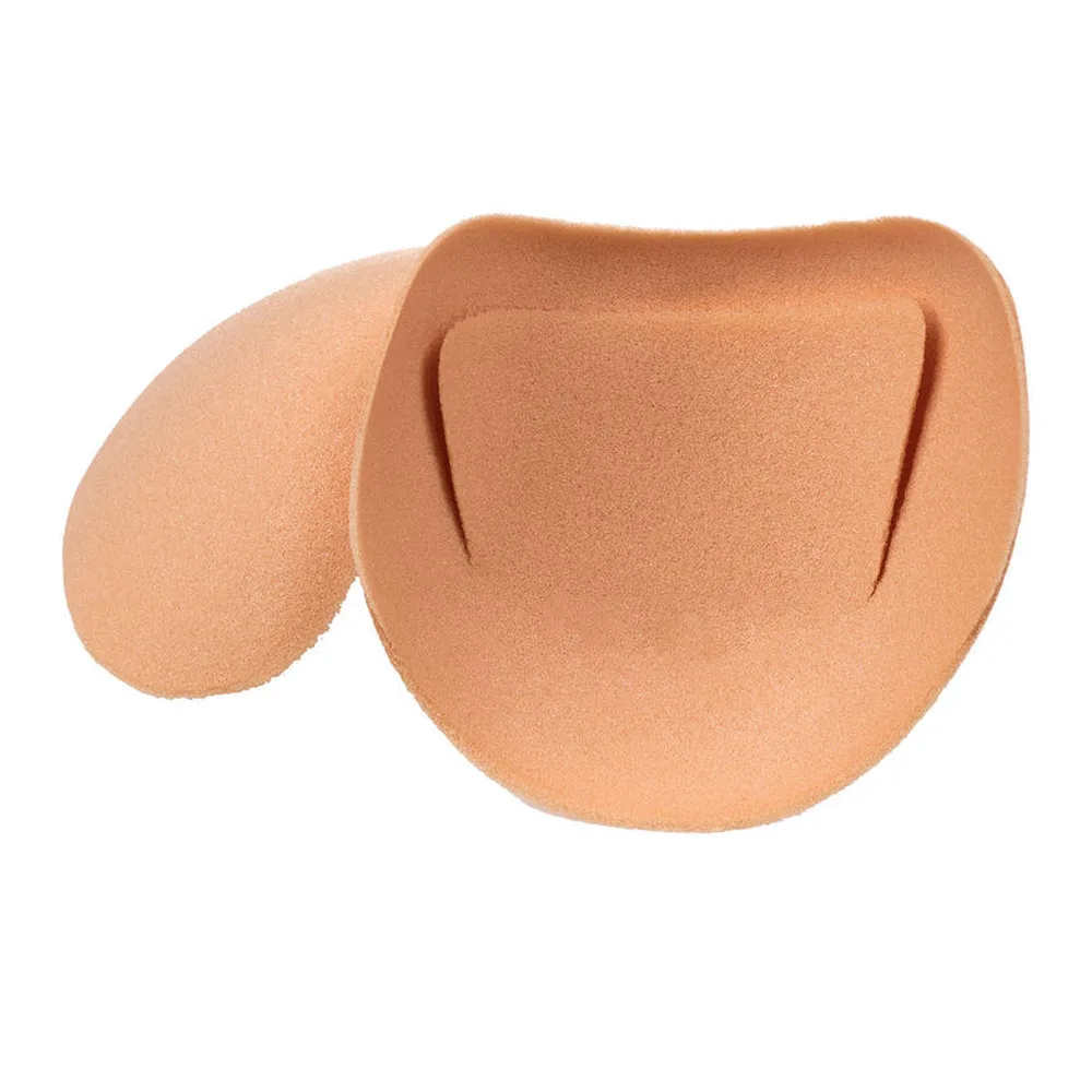 Paire de protecteurs d'épaules en mousse beige chair, de forme arrondie avec une découpe en demi-lune sur le dessus, sur fond blanc
