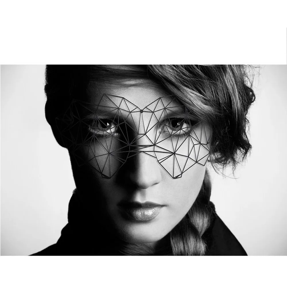 Masque en vinyle noir au motif géométrique ajouré de triangles interconnectés, formant un effet de filet sur le visage