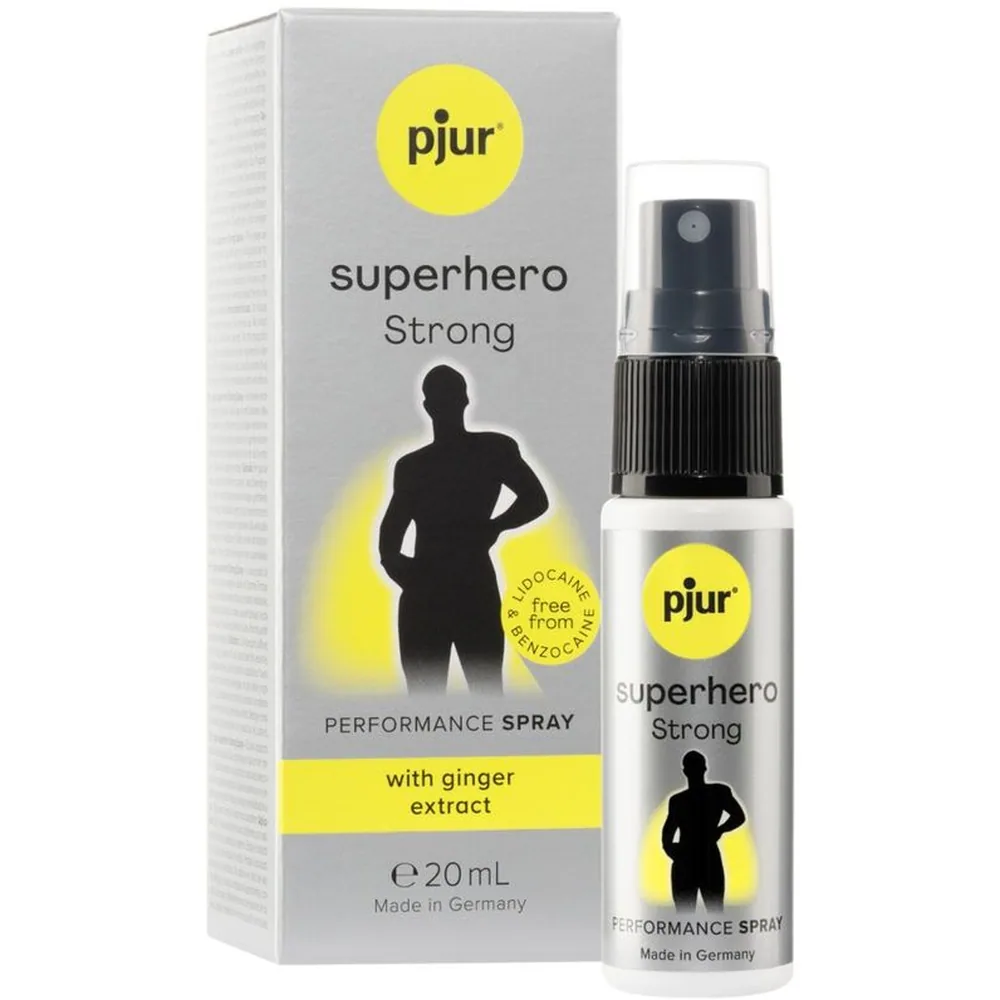 Emballage et flacon spray du performance spray Superhero Strong pjur 20 ml, avec étiquette jaune indiquant absence de lidocaïne et benzocaïne, et mention d'extrait de gingembre