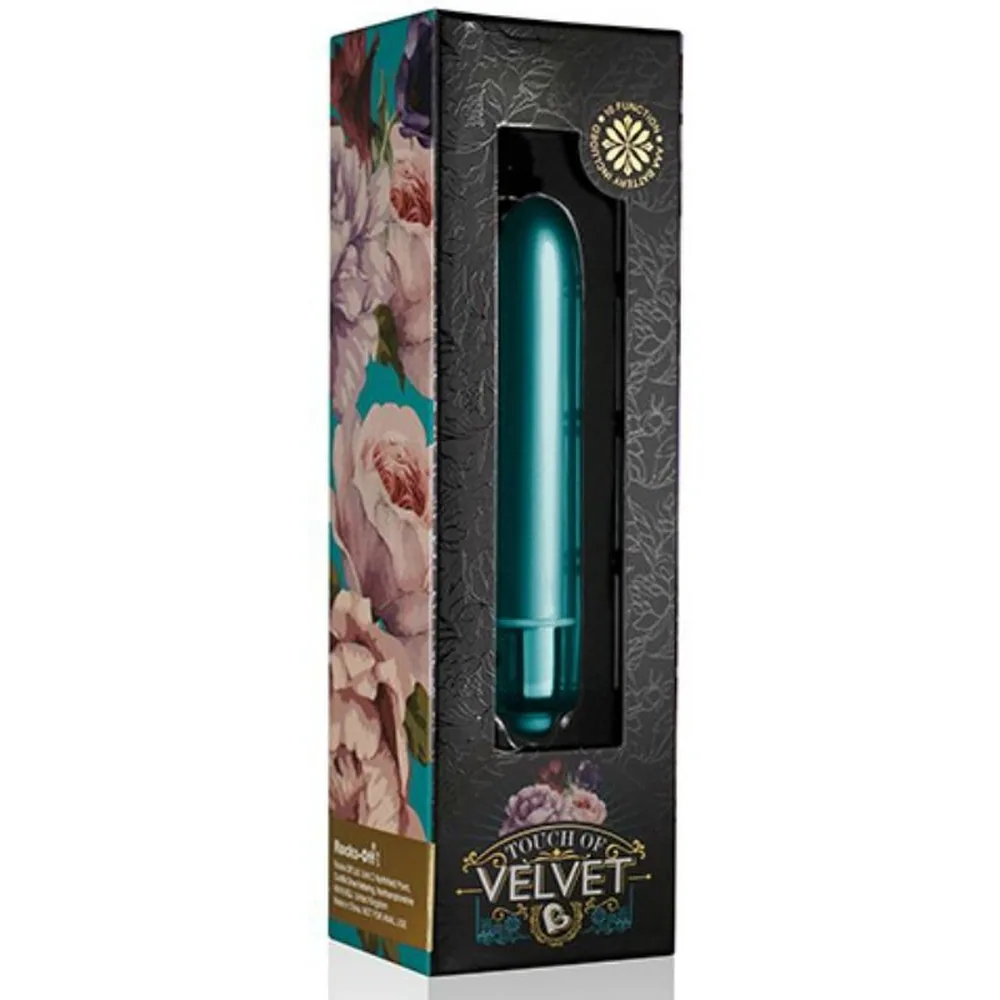 Vibromasseur allongé teal avec embout arrondi et corps lisse en finition satiné, base chromée contrastante sur fond blanc