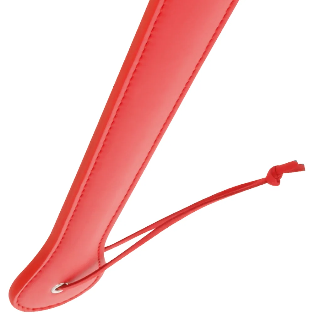 Paddle fétiche rouge vif avec manche long et étroit, embout arrondi, lanière d'attache assortie au bout du manche, sur fond blanc