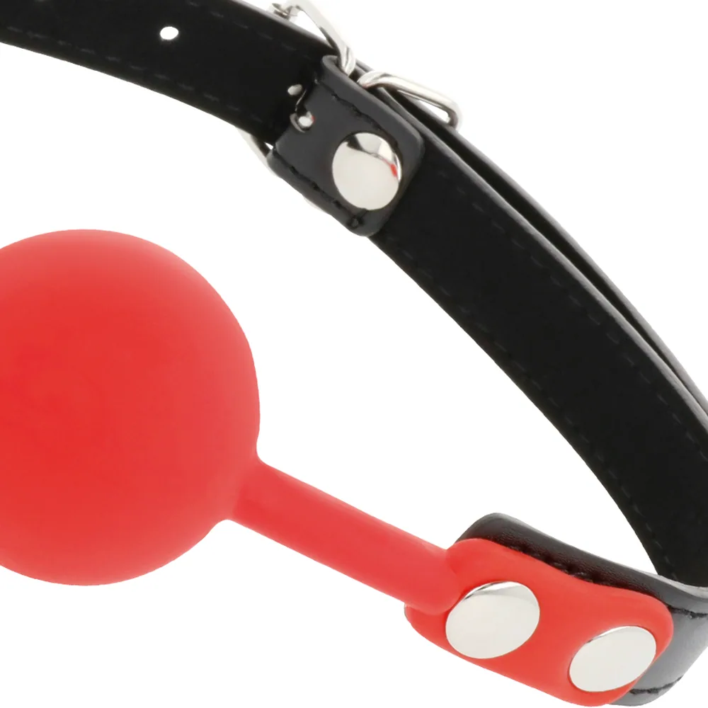 Bâillon à boule en silicone rouge avec sangle noire à rivets argentés, présenté avec son emballage rose et noir de la marque Darkness