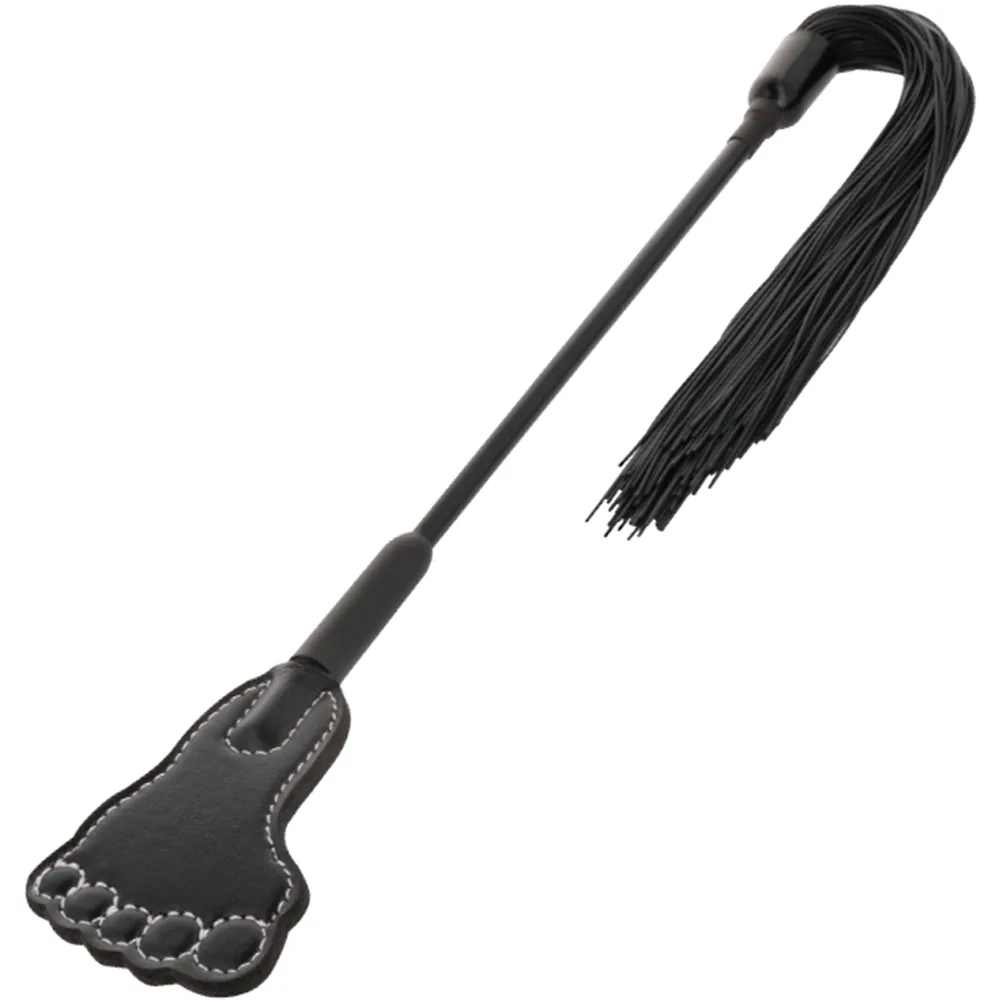 Cravache noire avec manche rigide, palette en forme de pied à une extrémité avec coutures apparentes, touffe de lanières fines à l'autre extrémité, sur fond blanc