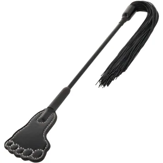 Cravache noire avec manche rigide, palette en forme de pied à une extrémité avec coutures apparentes, touffe de lanières fines à l'autre extrémité, sur fond blanc