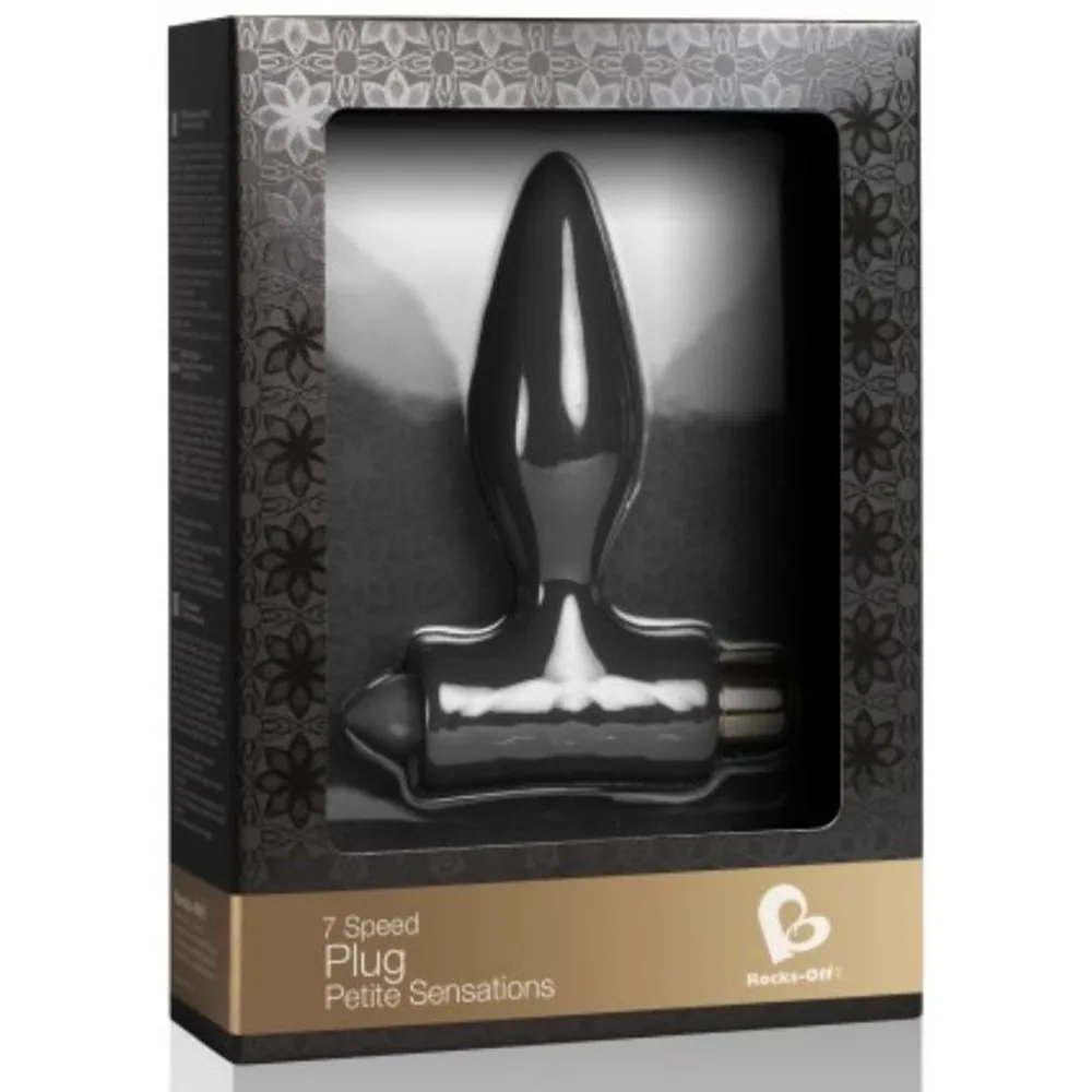 Plug anal noir en silicone tenu dans une main, base évasée en T, embout conique pointu, détails de texture visibles, batterie dorée intégrée