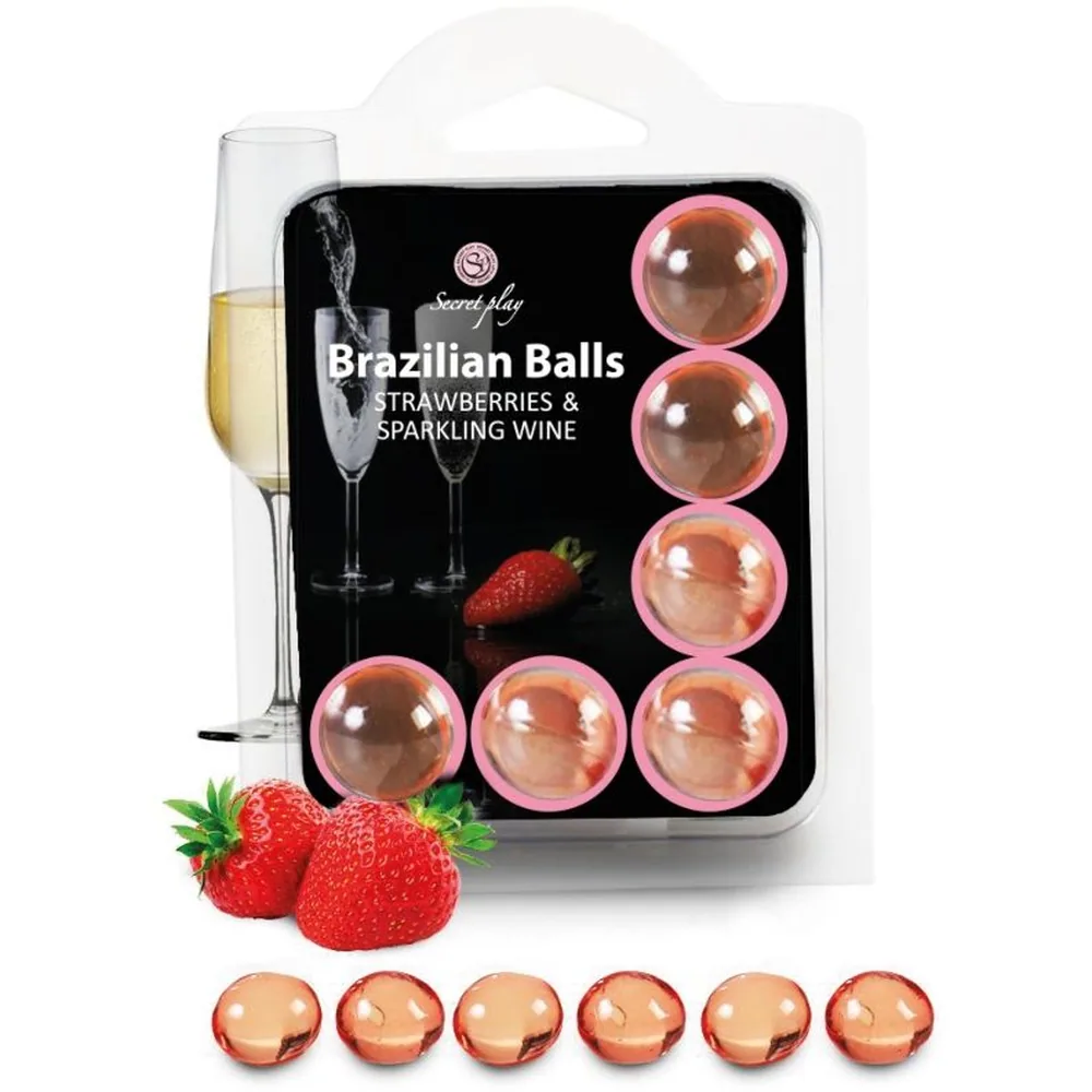 Emballage de boules brésiliennes fraises et vin pétillant avec six billes roses translucides en verre, fraises fraîches et verre de champagne blanc