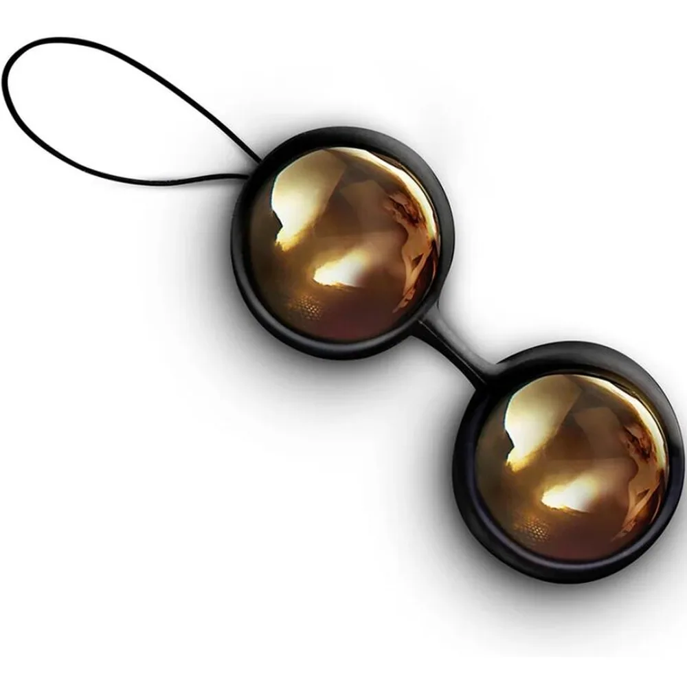 Boîte de présentation gris anthracite ouverte contenant deux boules de Geisha lisses, dorées, nichées dans un écrin noir, avec poignées dorées et inscription "LUST OBJECTIFIED"