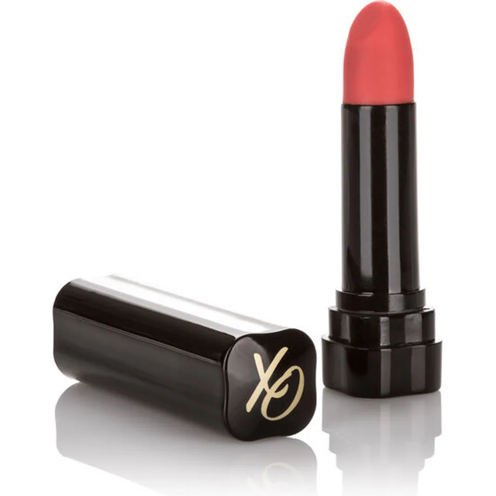 Stimulateur clitoridien en forme de rouge à lèvres avec bille vibrante rose corail et tube noir brillant avec capuchon, à côté de son étui cylindrique noir avec logo doré