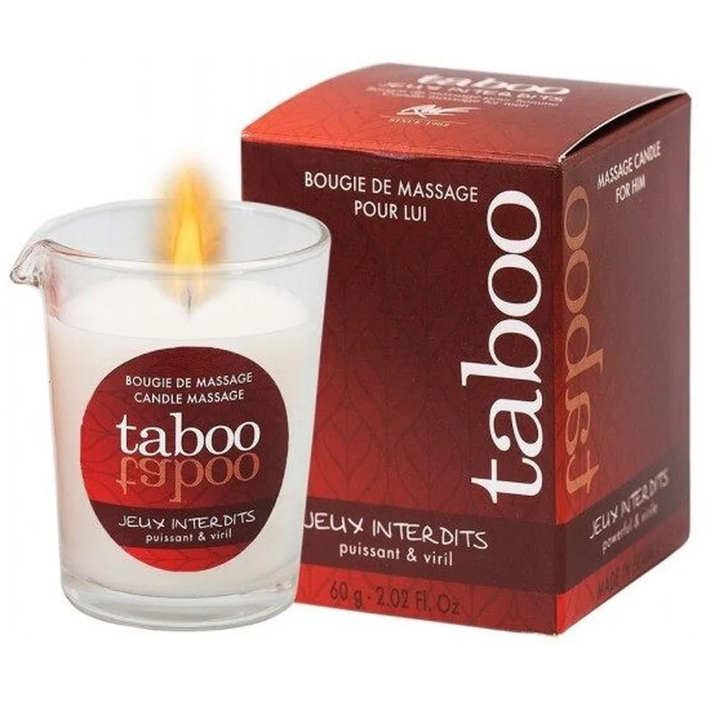 Bougie de massage allumée dans un pot en verre transparent, cire blanche avec flamme jaune vive, étiquette rouge foncé Taboo Jeux Interdits visible sur le devant