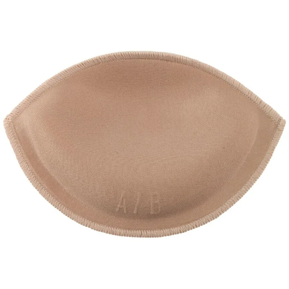 Femme portant un soutien-gorge beige clair avec coussinets, souriant, mains croisées sur la poitrine, fond blanc