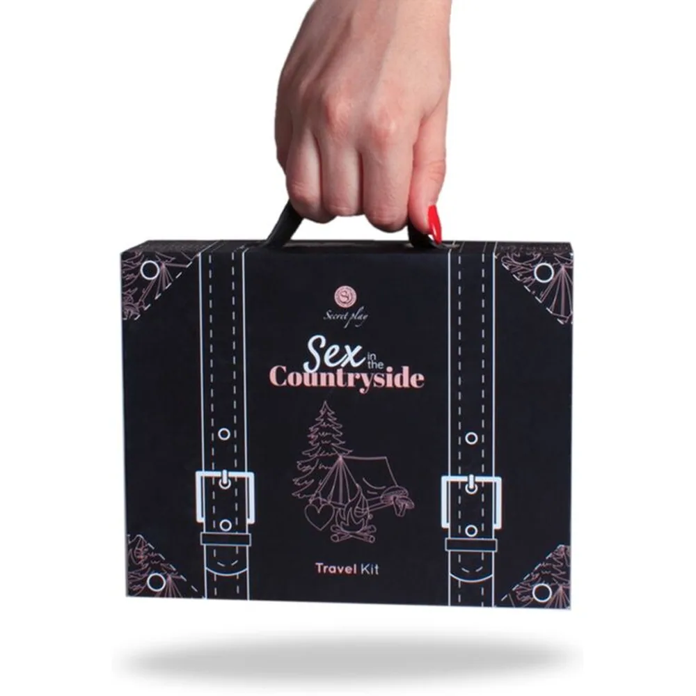 Coffret Travel Kit Sexe à la Campagne en forme de valise noire à motifs, contenant un vibromasseur rose, des sachets de lubrifiant, des cartes de défis roses et des accessoires d'intimité