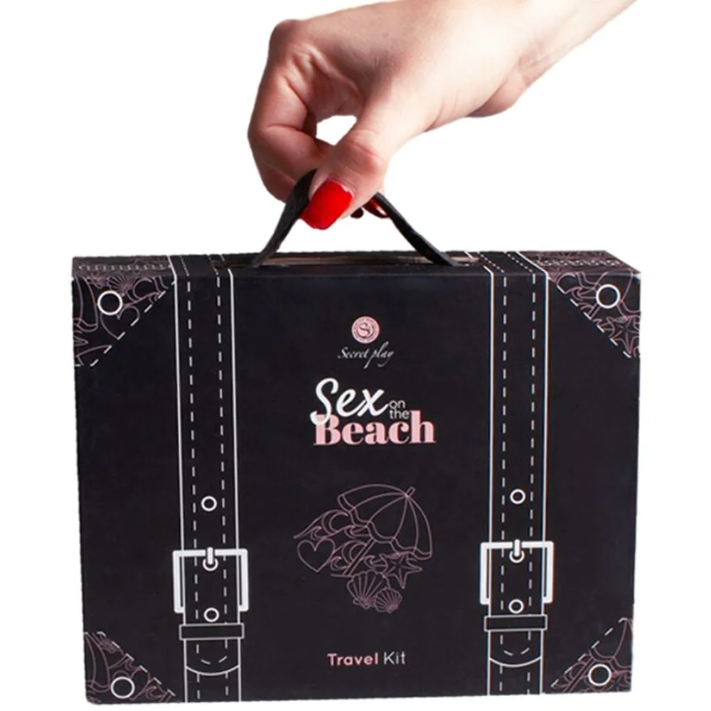 Emballage du kit de voyage Sexe sur la Plage : valise cartonnée noire à motifs, contenant un vibromasseur rose, des sachets individuels, des cartes rose avec défis, et un dé rose