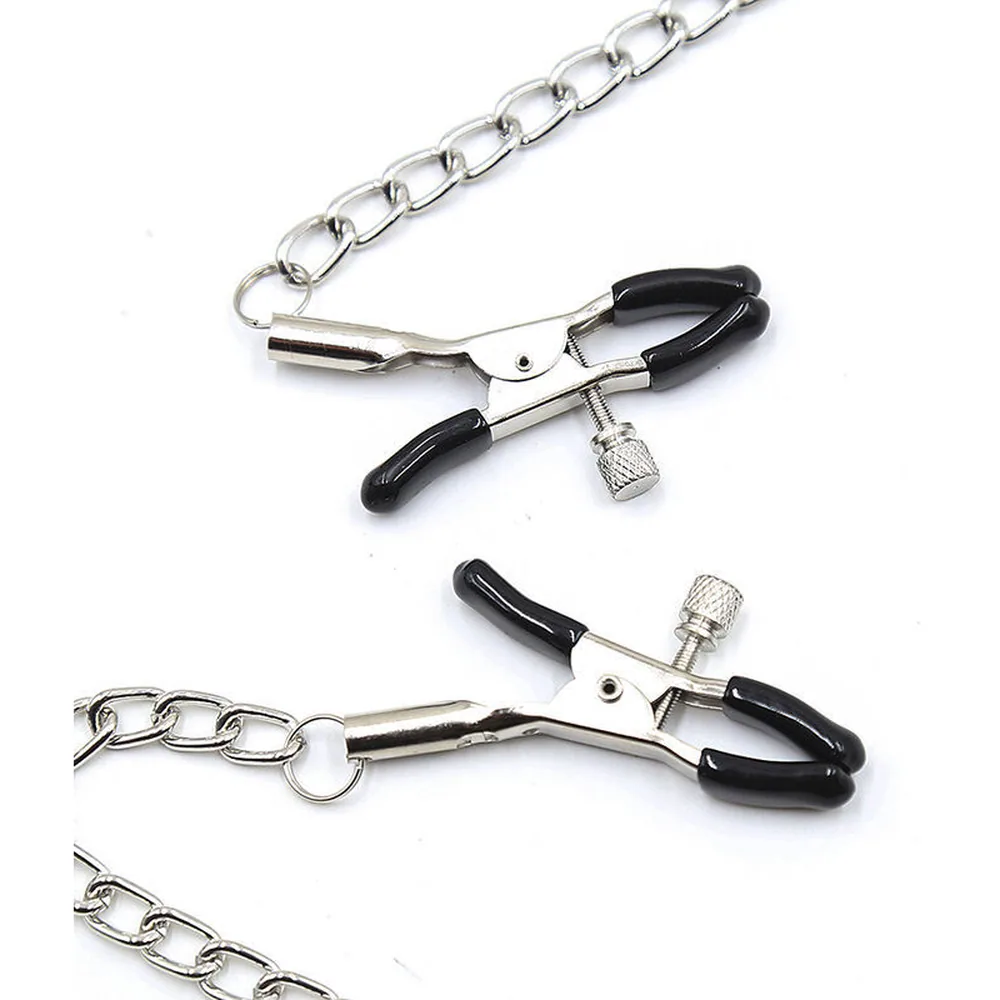 Baillon boule noir avec sangle ajustable en cuir perforé, accompagné de deux chaînes transparentes terminées par des pinces à tétons noires