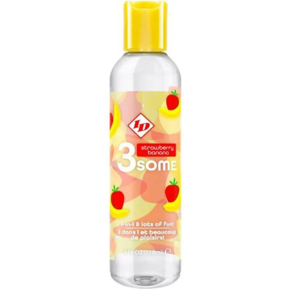 Bouteille de lubrifiant comestible fraise-banane avec bouchon jaune, étiquette colorée illustrée de fraises et bananes sur fond dégradé pêche et jaune