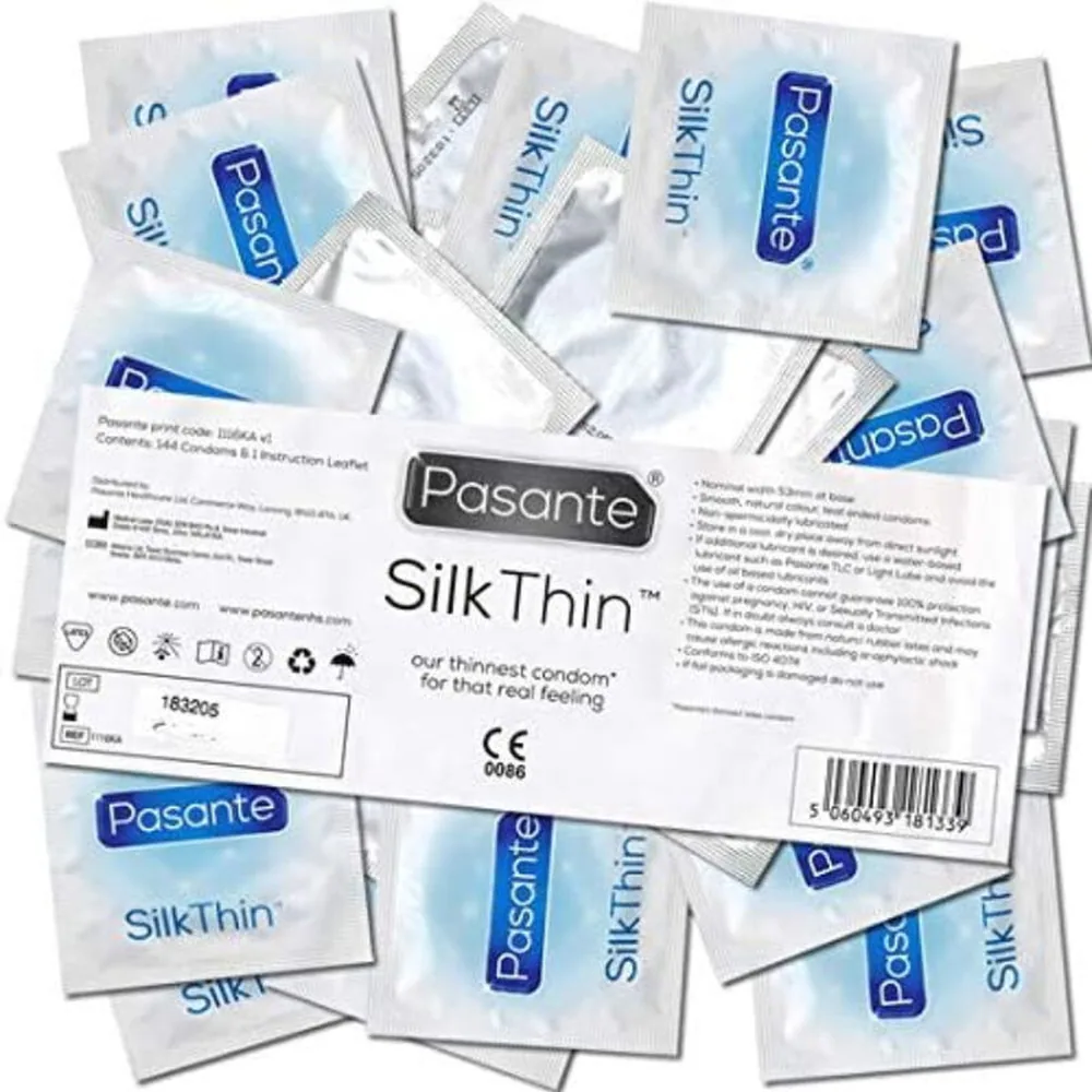 Boîte de 144 préservatifs Pasante SilkThin en latex transparent avec sachets individuels ouverts autour, montrant l'emballage blanc et bleu et les instructions de sécurité