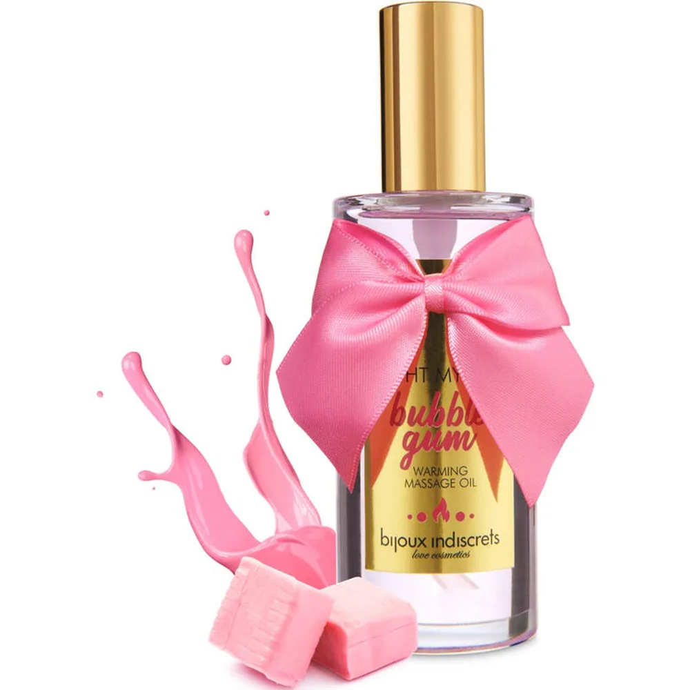 Flacon de verre contenant une huile de massage rose pâle, bouchon doré, orné d'un nœud rose vif, étiquette jaune mentionnant bubble-gum et huile de massage chauffante