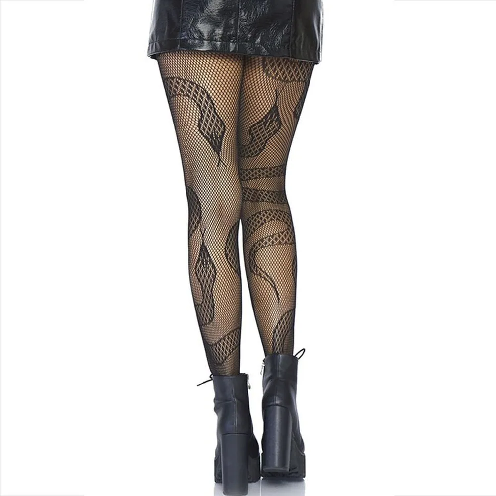 Collant en résille noire à motif serpent stylisé courant sur les jambes, porté avec un short noir et des boots à talons