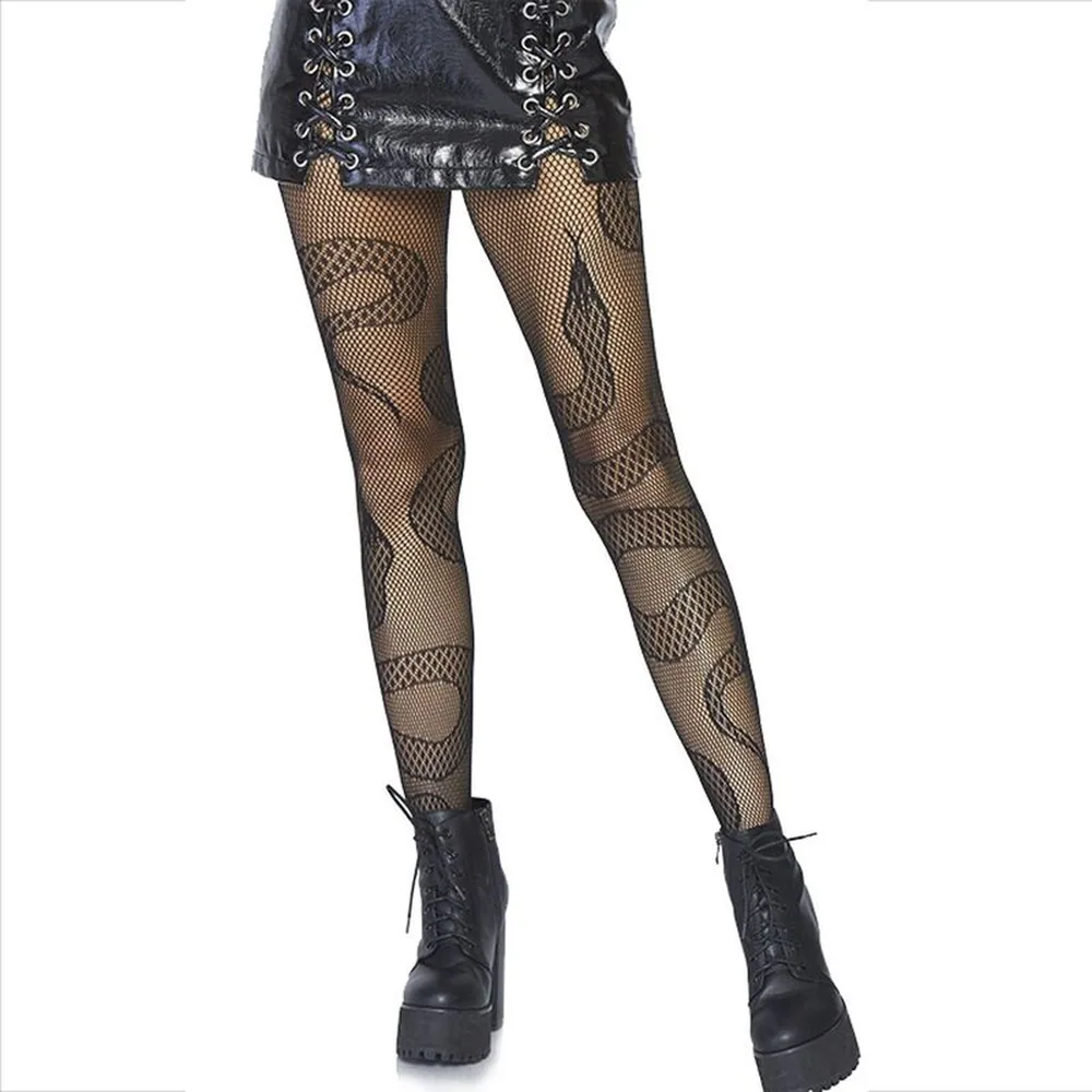 Collant en résille noire à motif serpent stylisé courant sur les jambes, porté avec un short noir et des boots à talons