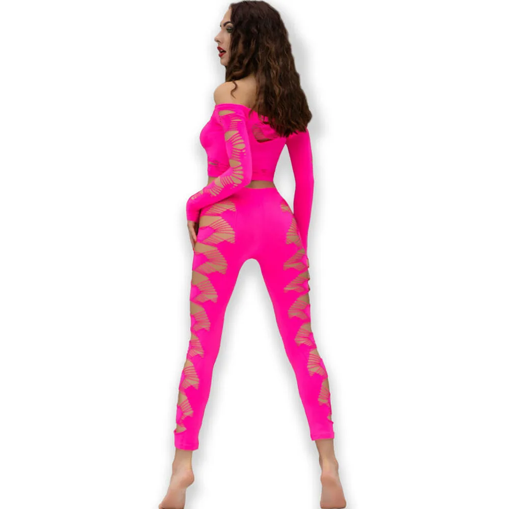 Ensemble fuchsia composé d'un crop top et d'un legging sans couture, tous deux ornés de découpes ajourées sur les côtés et les jambes, porté de profil sur fond blanc