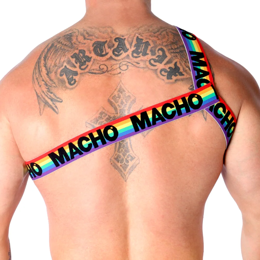 Harnais de poitrine avec sangles arc-en-ciel siglées « Macho », porté sur le dos nu d'un homme tatoué, fond blanc
