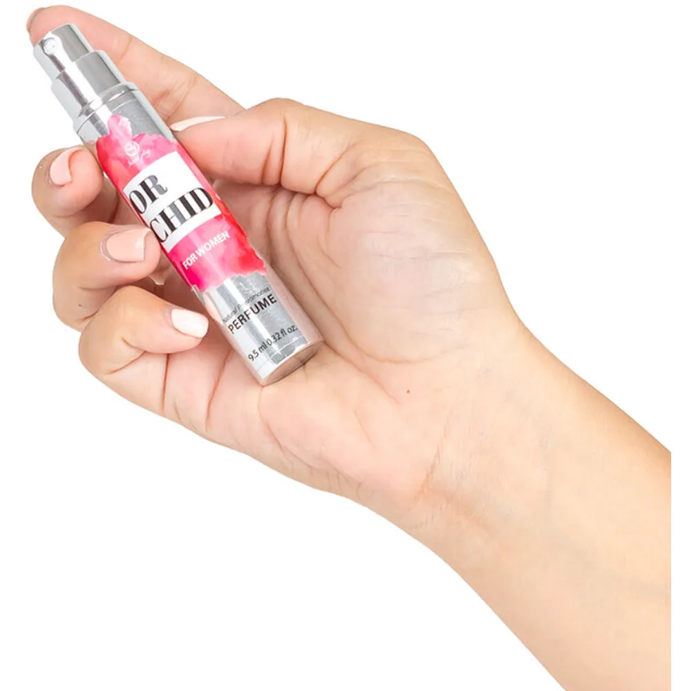 Flacon spray de parfum aux phéromones blanc et chromé de 9,5 ml, décor floral rose fuchsia, étiquette noire « ORCHID FOR WOMEN », embout pulvérisateur avec chaîne argentée