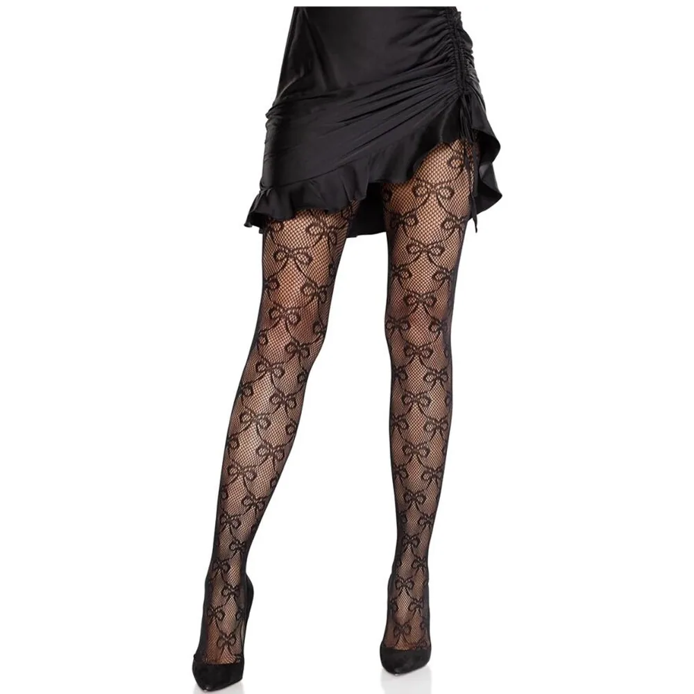 Collant résille noir avec motif de nœuds géométriques, porté avec un short noir et des chaussures à talons noirs