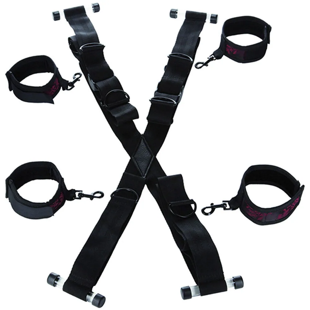 Ensemble de bondage noir composé d'une croix de fixation sur porte avec deux bandes larges croisées, quatre manchettes rembourrées avec intérieur rouge et chaînes de liaison, sur fond blanc