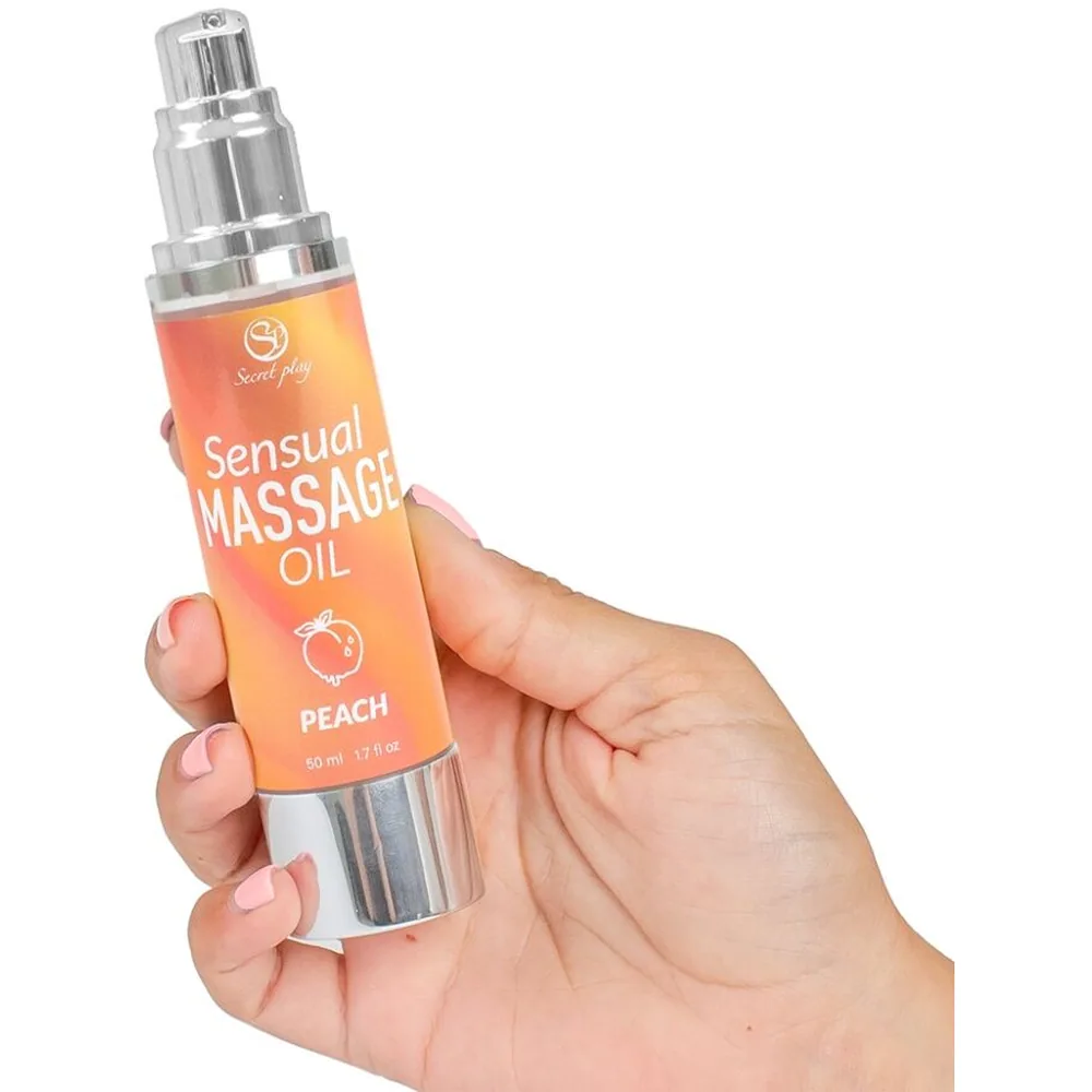 Flacon airless blanc de 50 ml d'huile de massage parfum pêche, étiquette orange avec logo Secret play et inscription Sensual Massage Oil