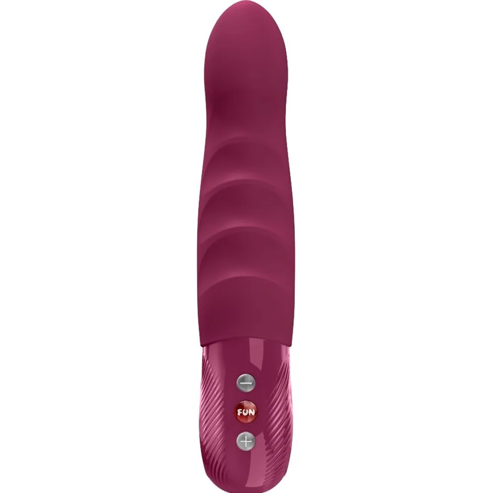 Stimulateur clitoridien en silicone bordeaux avec pointe arrondie, texturé de vagues sur le corps, commandes tactiles et grip texturisé rose à la base, sur fond blanc