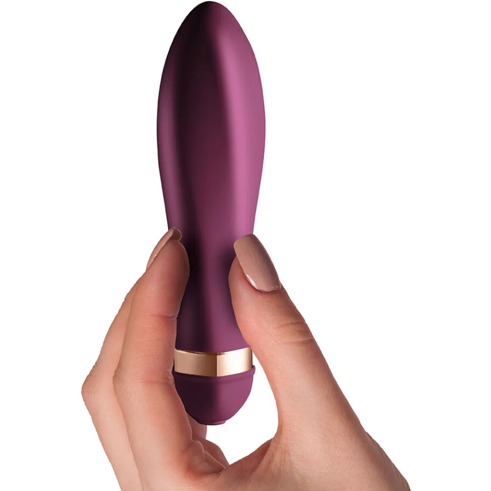 Vibrateur de forme élancée en silicone bordeaux avec anneau doré à la base et embout arrondi, fond blanc
