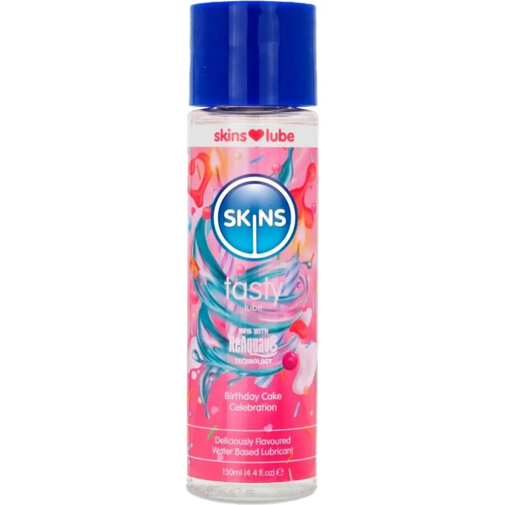 Flacon transparent de lubrifiant à base d'eau Skins Fantasies, 130 ml, avec étiquette rose décorée de motifs floraux et capuchon bleu, saveur gâteau d'anniversaire