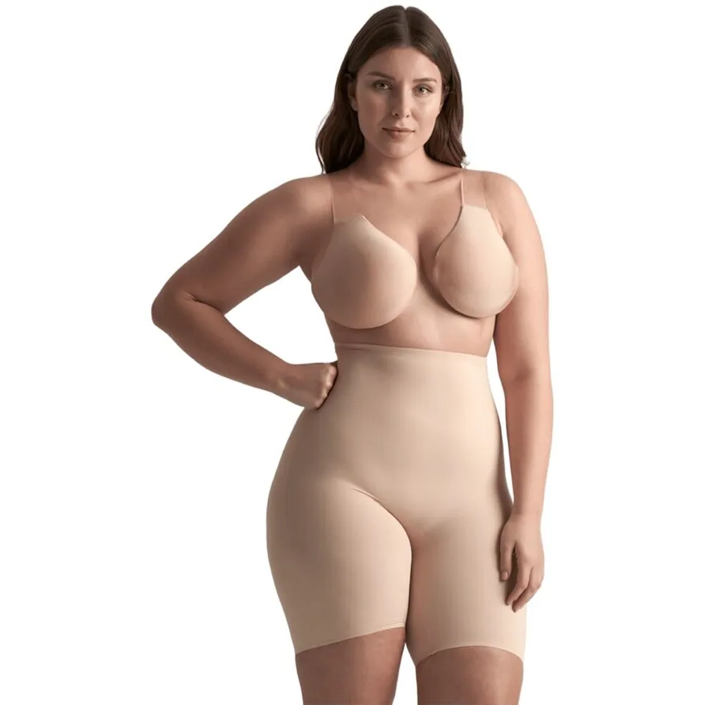 Femme portant un soutien-gorge beige sans armatures avec coques adhésives et culotte gainante assortie sur fond blanc