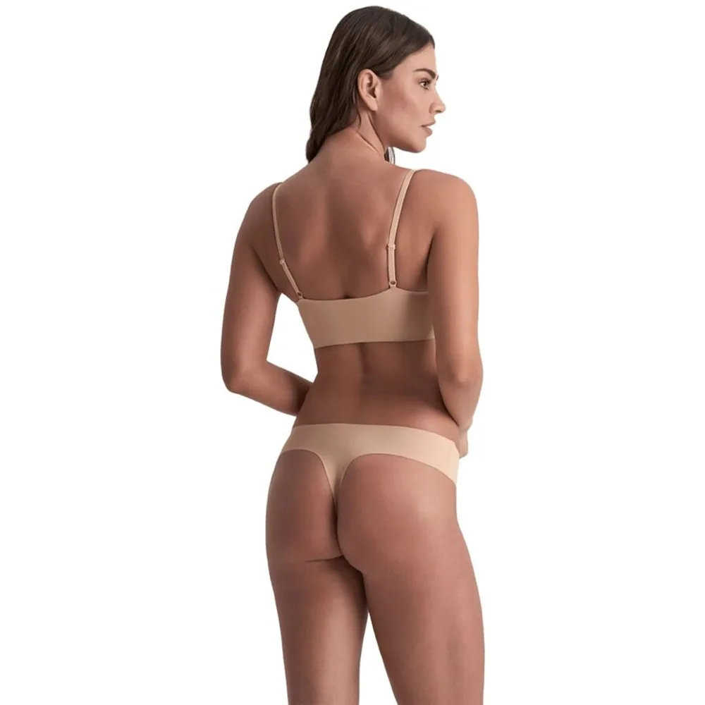 Femme portant un soutien-gorge noir à armatures et un string noir sans couture sur fond blanc