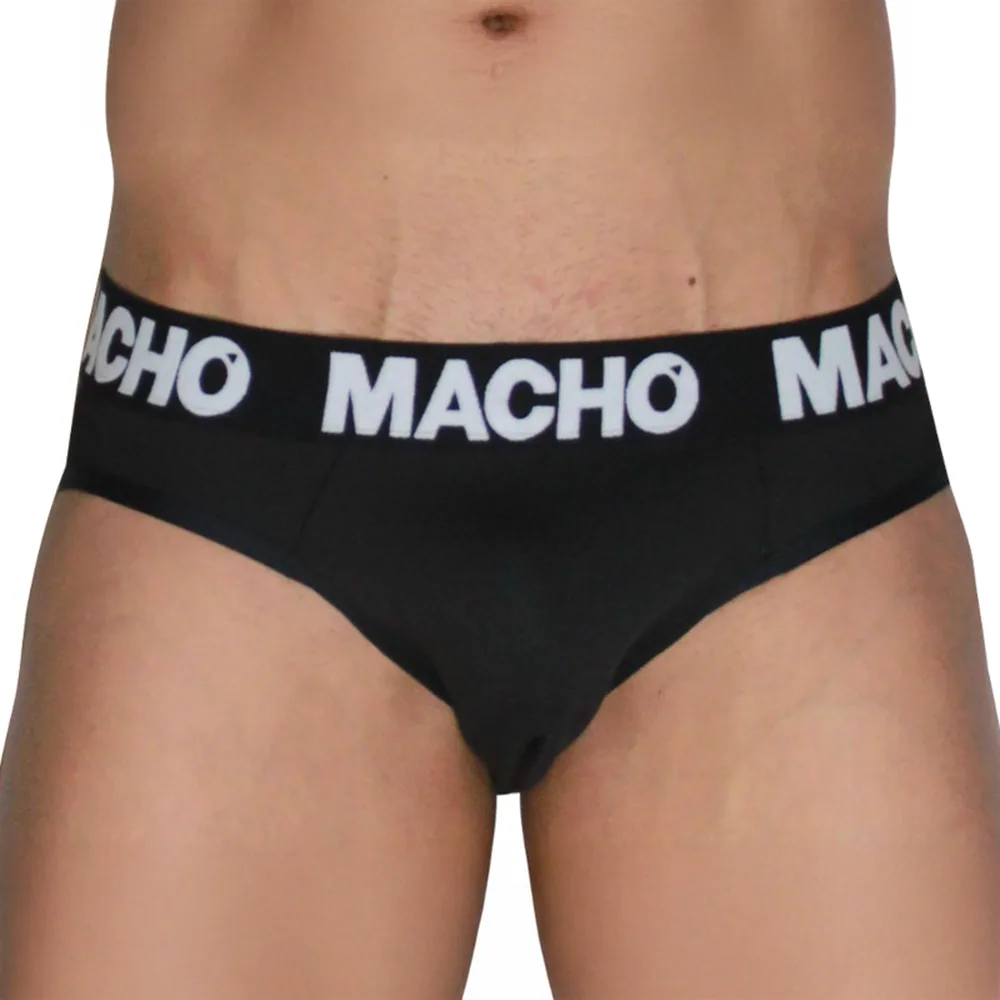 Slip noir porté, ceinture élastique blanche à rayures avec texte « MACHO », taille ajustée pour discrétion sous vêtements