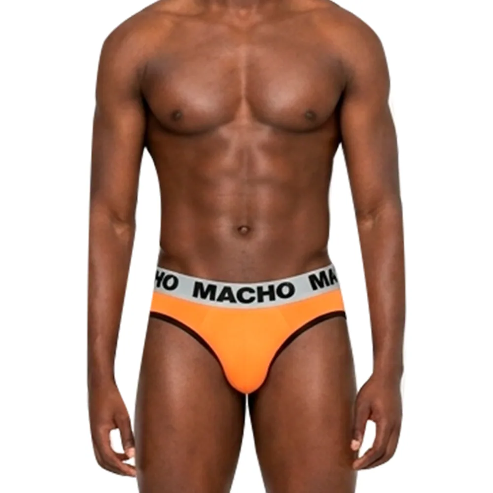 Slip orange vif avec bande élastique blanche inscrite "MACHO", coque avant structurée, porté par un homme sur fond neutre
