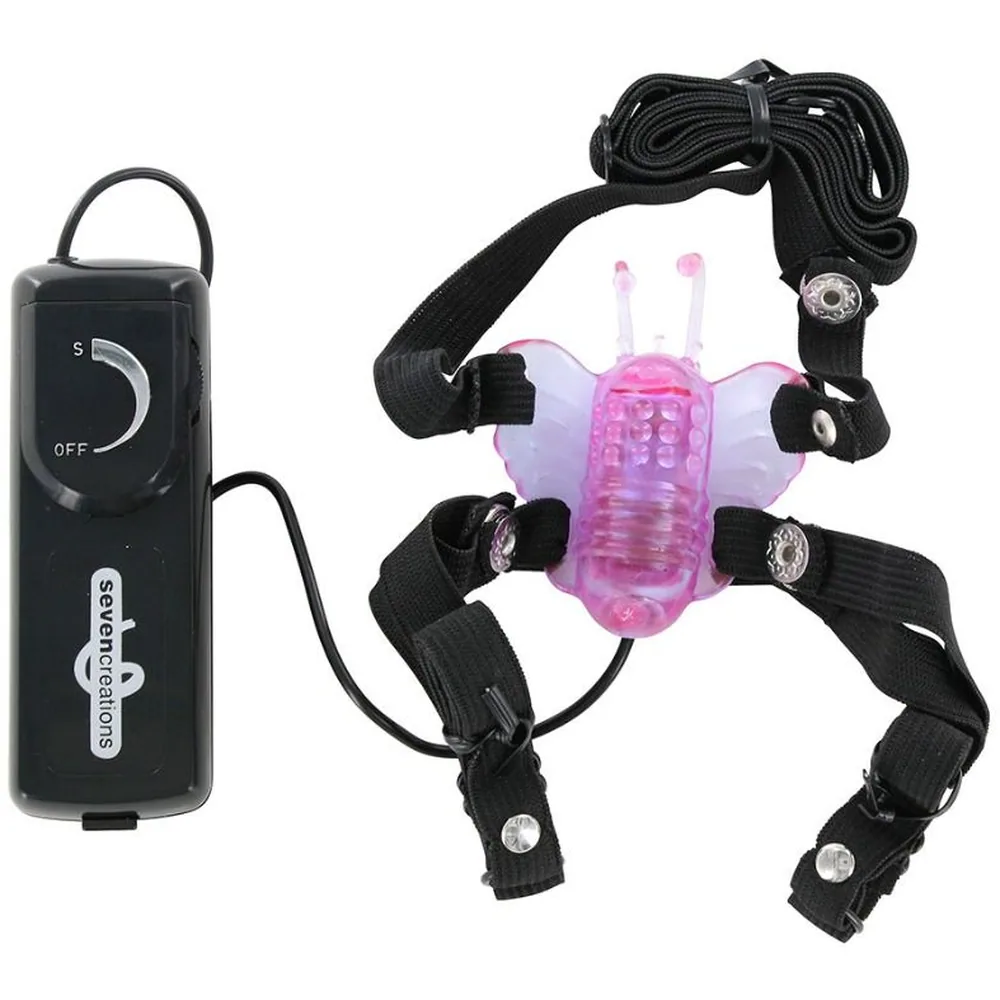 Stimulateur papillon rose transparent avec antennes, attaché à quatre sangles noires munies de boucles, et son boîtier de contrôle noir avec curseur réglable et câble de charge