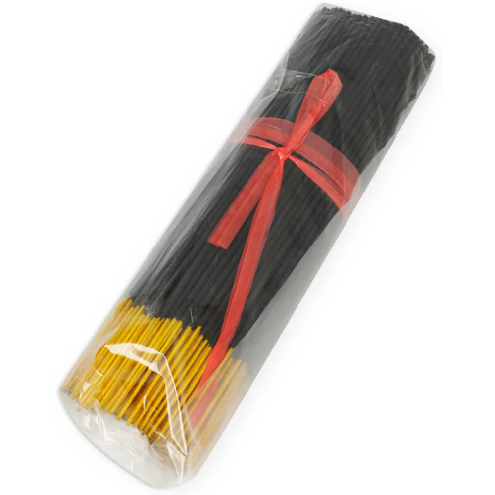 Paquet d'encens noir et or avec ruban rouge, sous emballage plastique transparent. Les bâtons noirs occupent la majorité du paquet, les tiges dorées visibles à la base